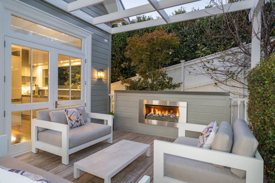 Outdoor patio with wall lantern beside an outdoor fireplace