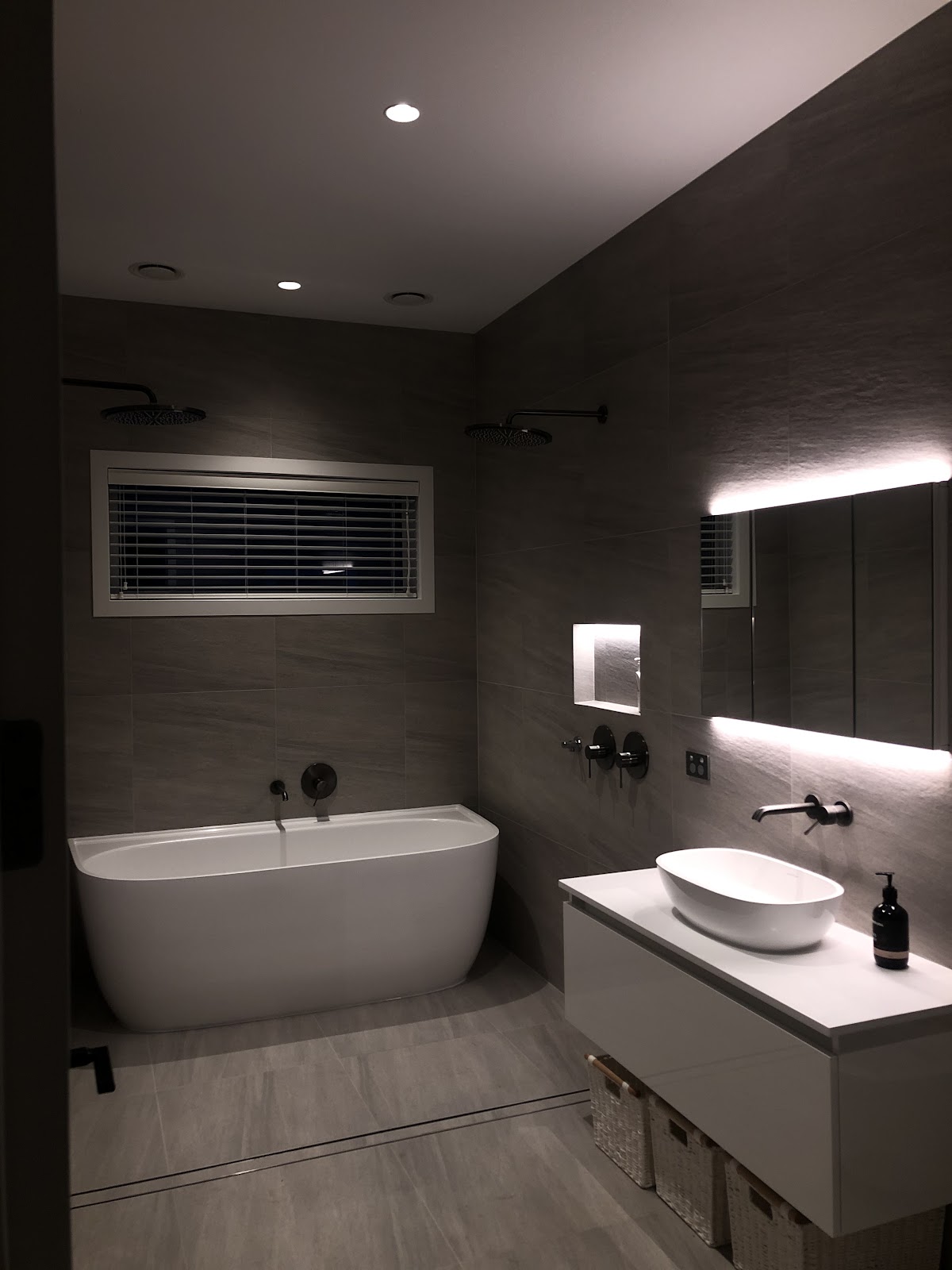 Bathroom with LED backlit mirrors and recessed ceiling lighting